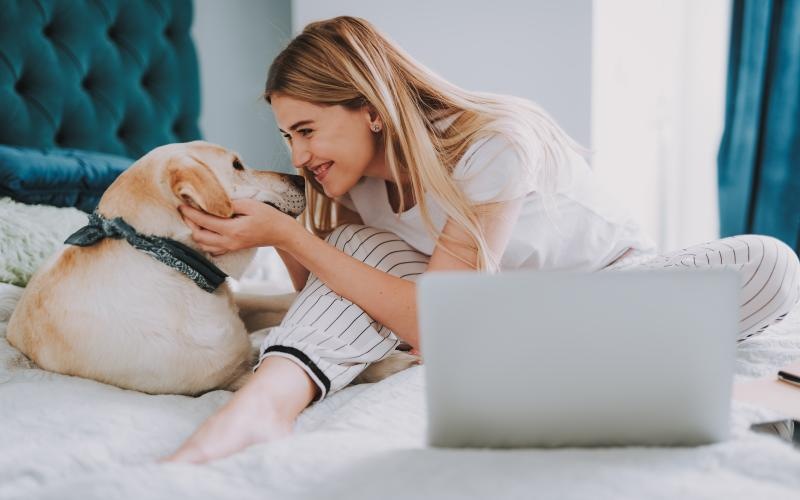 a woman and a dog on a bed