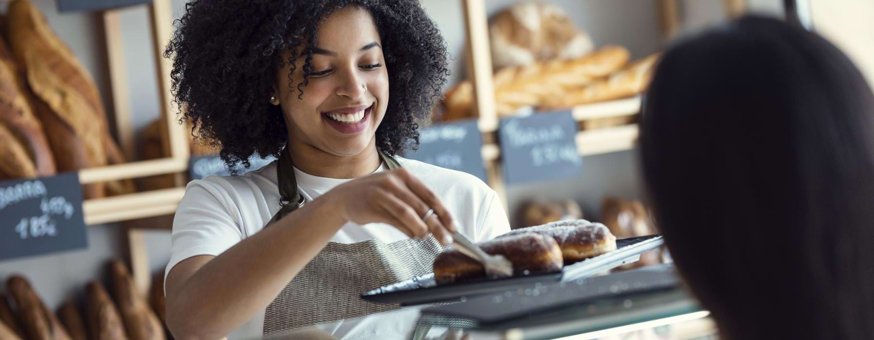 a person holding a tray of donuts